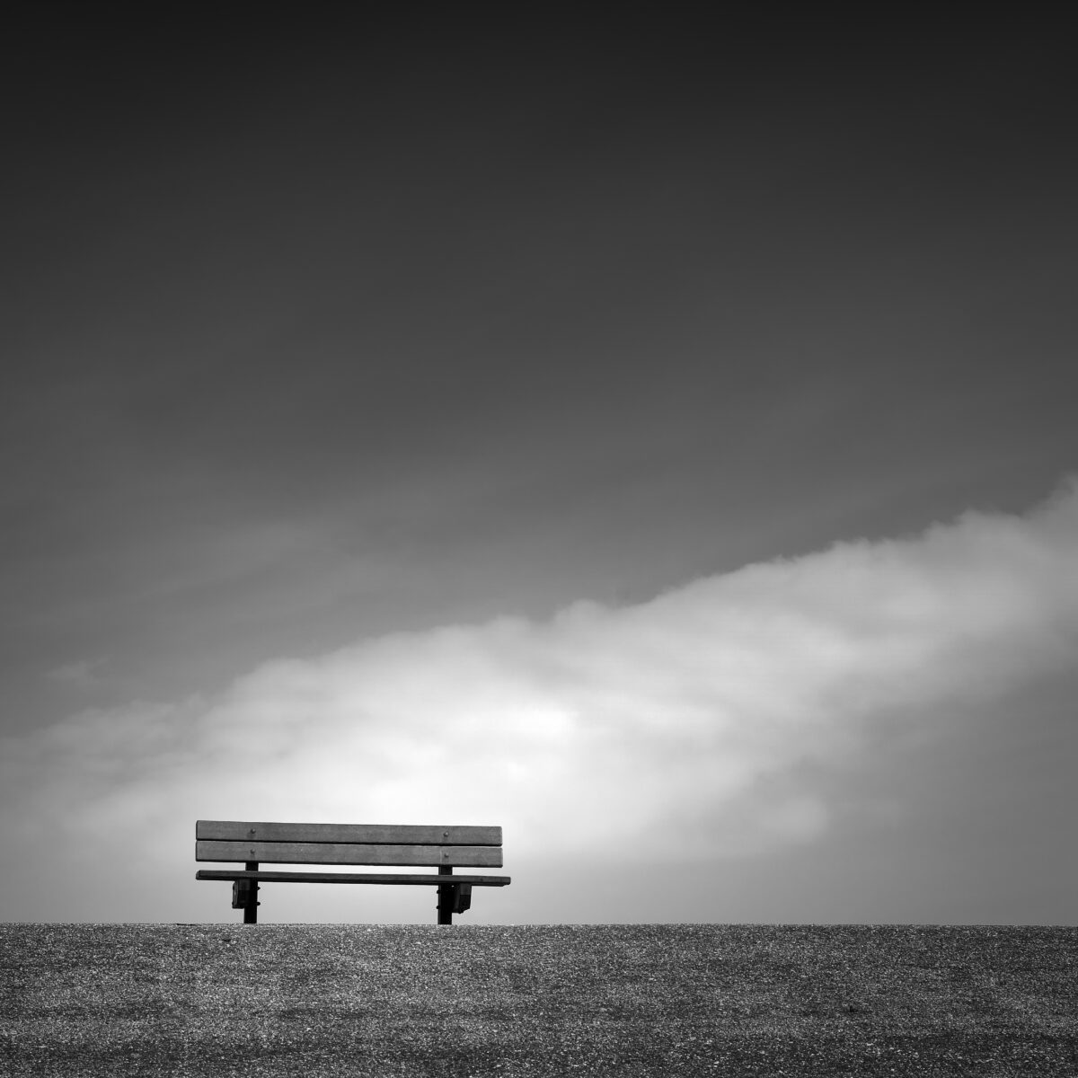 Bench on a dike in black and white
