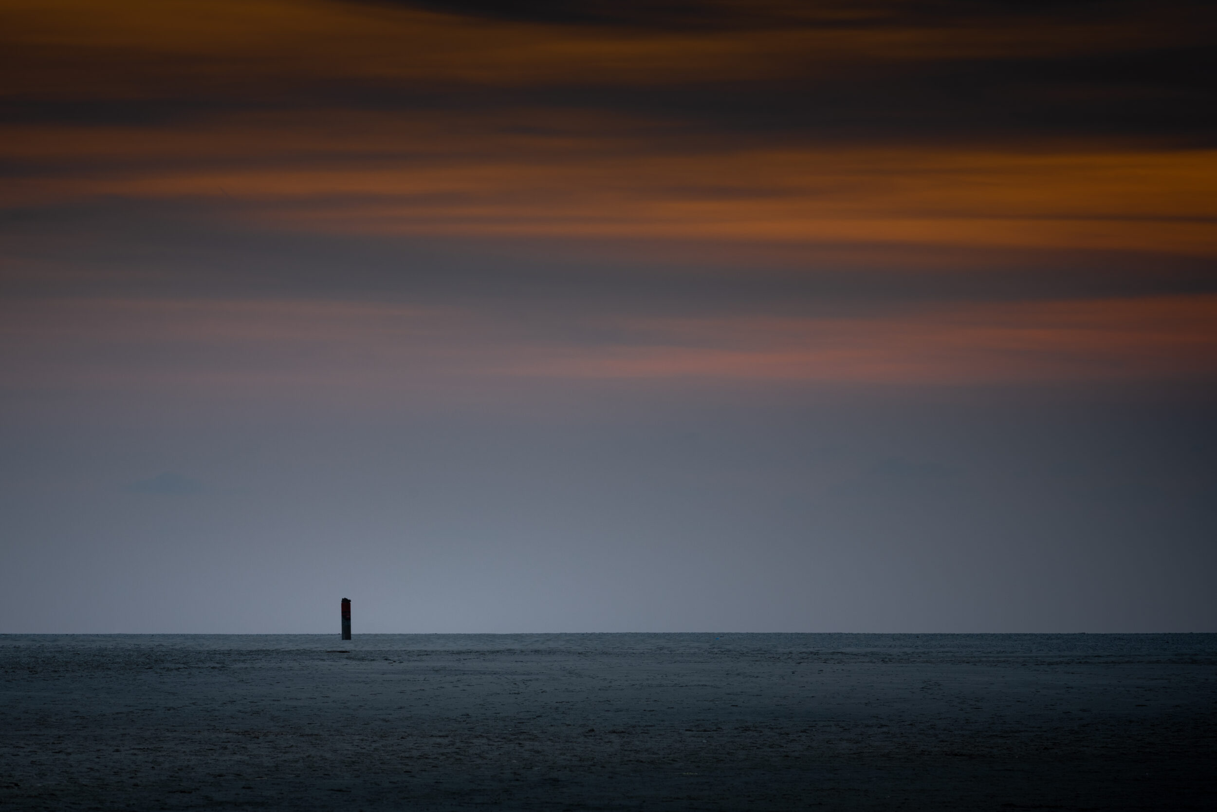 Lone beach pole during sunset